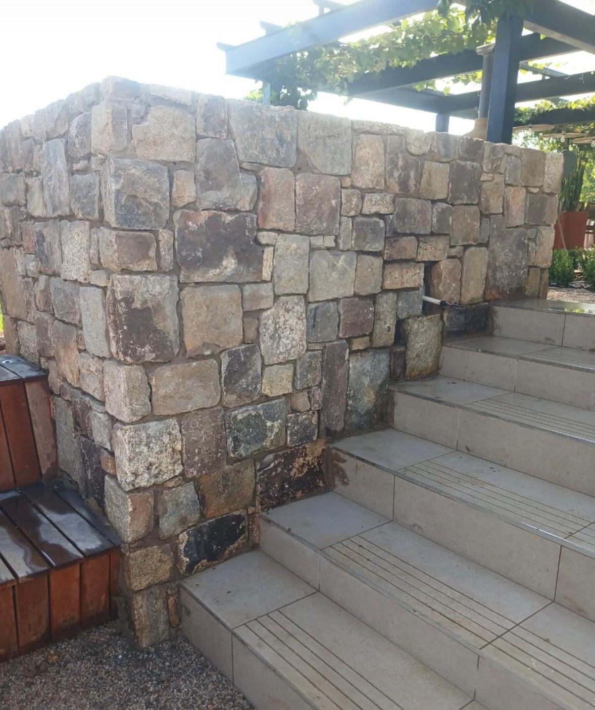 Natural stone wall adjoining a residential stairway.