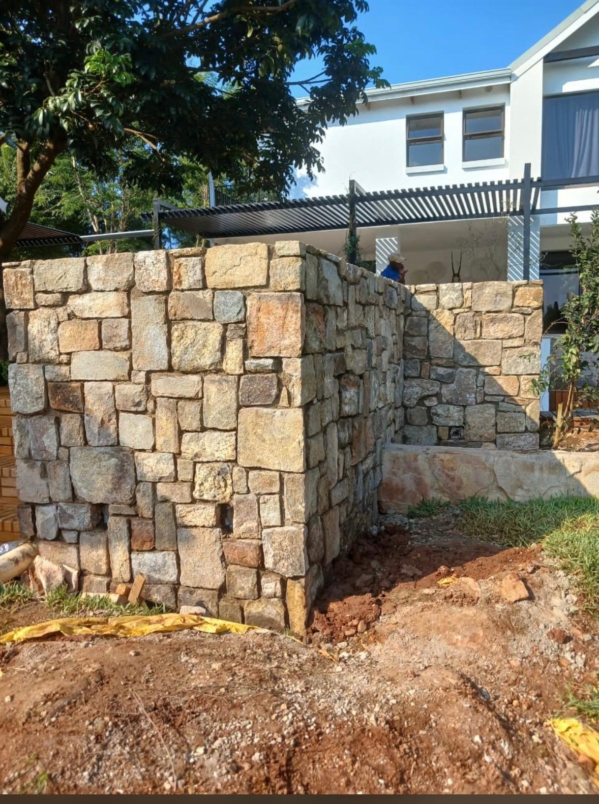Natural stone wall finishes beside a residential entrance.